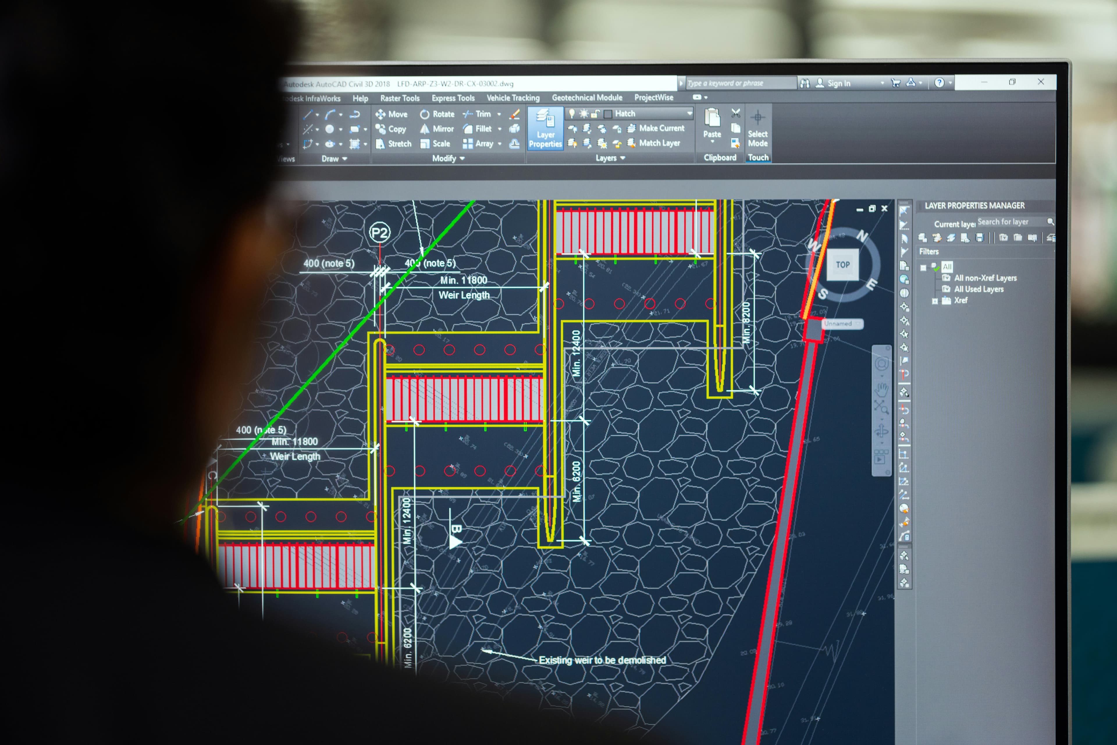Monitor exibindo projeto técnico no AutoCAD em estação de engenharia.