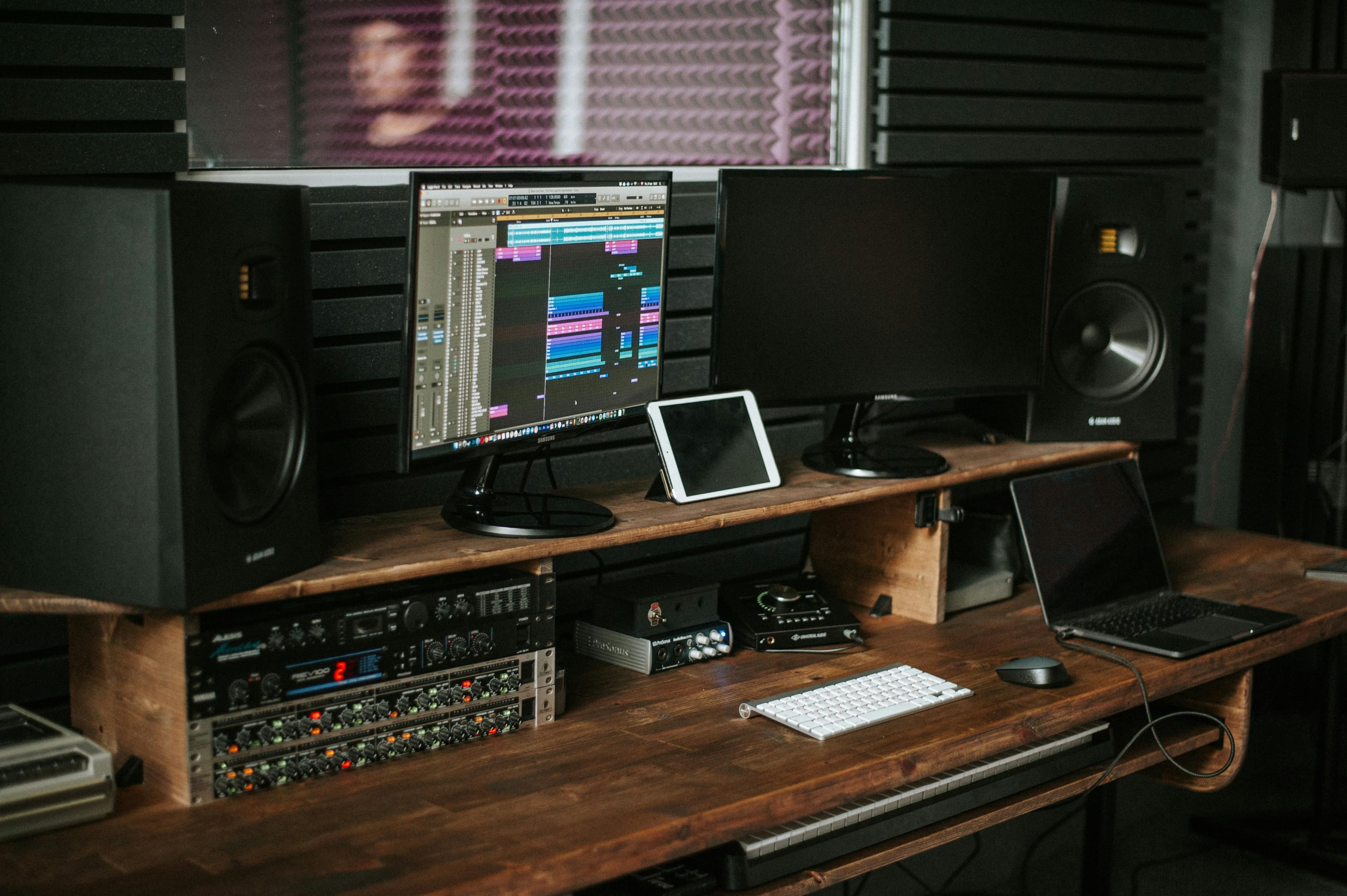 Estúdio de produção musical com monitores de áudio e estação de trabalho.